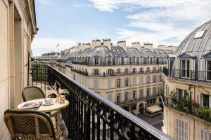 a balcony with a table and chairs and buildings at Normandy Le Chantier in Paris