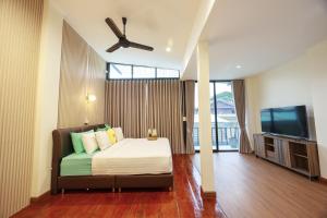 a bedroom with a bed and a ceiling fan at P.U. Inn Resort in Phra Nakhon Si Ayutthaya