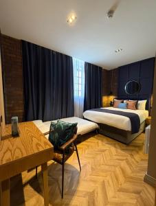 a hotel room with two beds and a table at Hütel in Liverpool