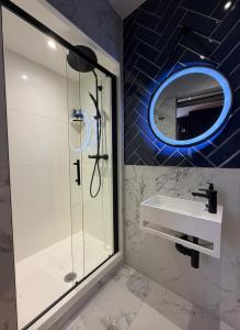 a bathroom with a shower and a sink and a mirror at Hütel in Liverpool