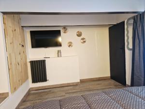 a room with a bed and a television on a wall at Retro Chic in Saumur