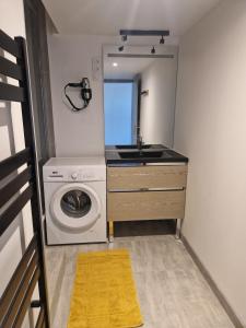 a small bathroom with a washing machine and a sink at Retro Chic in Saumur