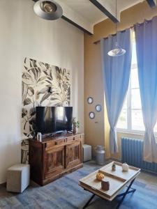 a living room with a television on a wooden entertainment center at Retro Chic in Saumur
