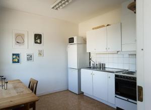 a kitchen with a white refrigerator and a table at Spjutstorp's old school and rectory, 1 in Tomelilla