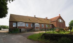a large brick house with white windows at Spjutstorp's old school and rectory, 1 in Tomelilla