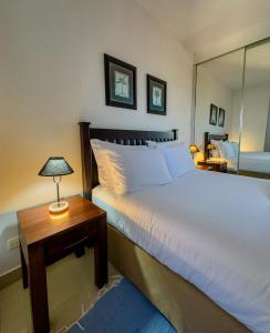 a bedroom with a bed and a table with a lamp at Vip Executive Suites Maputo in Maputo +3 photos