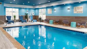 a pool in a hotel lobby with chairs and tables at Hampton Inn Chelsea, Mi in Chelsea