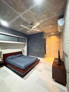 a bedroom with a bed and a desk in it at HomeWay Dhaka in Kāmarpāra