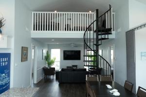 a living room with a black spiral staircase at Beach Front on West Beach in Galveston