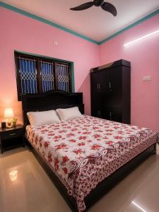a bedroom with a large bed with pink walls at Rose Villa Kovalam in Kovalam