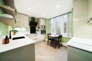 a kitchen with green walls and a table and chairs at The Copper Loft Apartment, Keith in Keith
