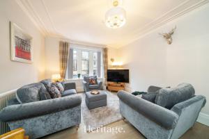 a living room with two couches and a tv at The Copper Loft Apartment, Keith in Keith