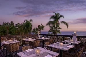 a restaurant with a view of the ocean at dusk at Mediterranean Beach Hotel in Limassol