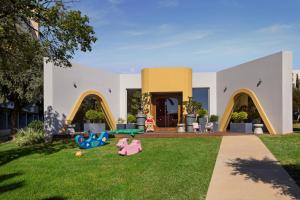 a house with a lawn with toys in the yard at Mediterranean Beach Hotel in Limassol +55 photos
