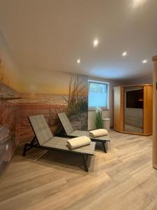 a living room with two chairs and a flat screen tv at Hotel Ostseewoge in Graal-Müritz