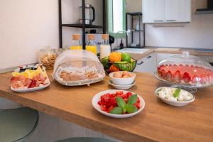 a counter with bowls of fruits and vegetables on it at Eterea Dimora Sul Fiume in Noto +26 photos