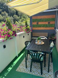a patio with a table and chairs and flowers at Casa Aurea in O Grove