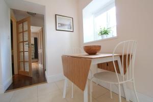 a dining room with a table and two chairs at The Lawns Spa Apartment in Holt