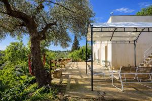 a shelter with chairs and a tree next to a building at Eterea Dimora Sul Fiume in Noto