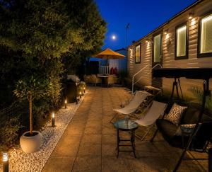 a patio at night with chairs and tables and lights at Seaside Escape at St Osyth in Clacton-on-Sea