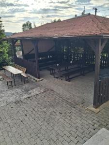 a pavilion with a picnic table and benches in it at Penzion Krušnohorka in Tatrovice