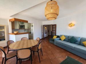 a living room with a blue couch and a table at 11A Rocha - Casas & Papeis in Armação de Pêra