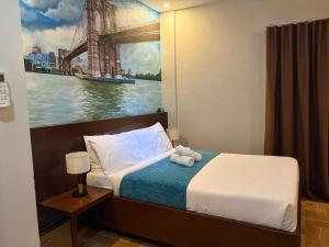a bedroom with a bed with a painting of a bridge at JJPHR Hotel San Antonio in Lubao +37 photos
