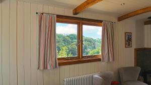 a window in a room with a view of trees at Betty Shepherd's Hut in Lydney