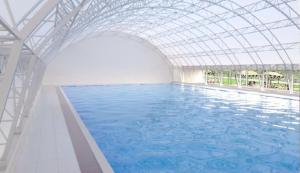 an indoor swimming pool with a glass ceiling at Apartman Anastasija in Guča