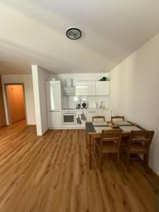 a living room with a table and chairs and a kitchen at Apartmán Na Hvězdné Mýtince in Jeseník