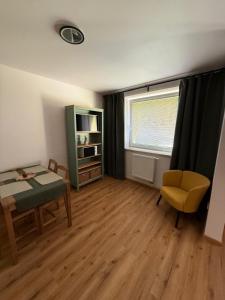 a small living room with a table and a chair at Apartmán Na Hvězdné Mýtince in Jeseník