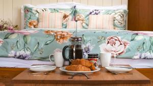 a coffee table with food on top of a bed at Betty Shepherd's Hut in Lydney
