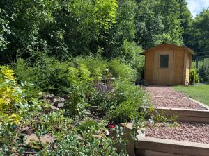 a garden with a small wooden shed in the background at Altum Mátra Vendégház in Mátraszentimre +31 photos