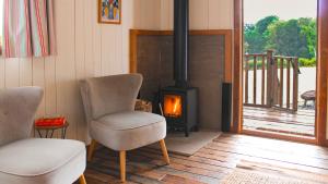 a living room with a chair and a fireplace at Betty Shepherd's Hut in Lydney