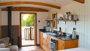 a kitchen with a stove top oven in a room at Betty Shepherd's Hut in Lydney +11 photos