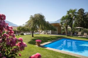 a yard with a swimming pool and a house at Hotel und Residence Johanneshof in Cermes