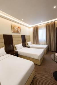 a hotel room with two beds and a table at فندق مرجانة الحجاز مكة المكرمة in Mecca +41 photos