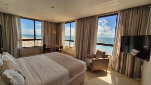 a hotel room with a large bed and a television at Niníve Boutique Hotel in Cabedelo