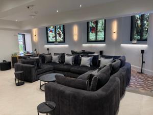a living room with couches and tables and stained glass windows at The North Wing in Stotfold