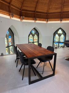 a wooden table with chairs in a room with stained glass at The North Wing in Stotfold