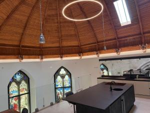 a church with a table and two stained glass windows at The North Wing in Stotfold