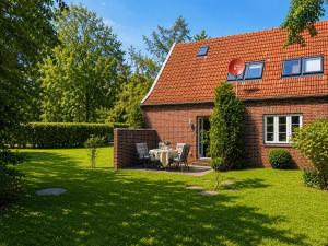 a house with a table and chairs in the yard at Zugvogel EG in Wangerland