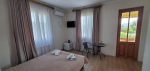 a hotel room with a bed and a table and a window at Mtskheta Pool and Veranda in Tsitsamuri