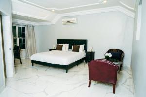 a bedroom with a bed and a chair at Adonai Hotel & Apartment in Spintex +5 photos