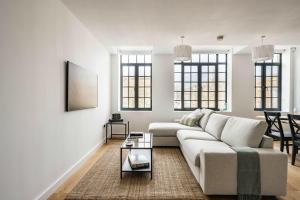 a white living room with a couch and a table at Seven Space - The Old Post Office Court in Norwich