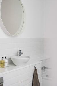 a white bathroom with a sink and a mirror at Seven Space - The Old Post Office Court in Norwich