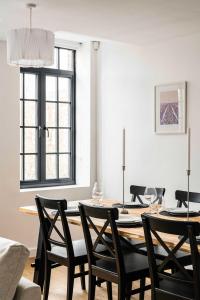 a dining room with a table with black chairs at Seven Space - The Old Post Office Court in Norwich