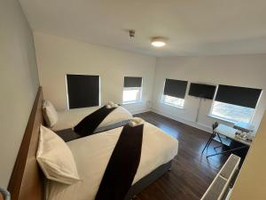 a bedroom with a bed and a desk and windows at Trivelles Liverpool in Liverpool