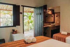 a hotel room with two beds and a kitchen at Pousada Coco Brasil in Caraíva
