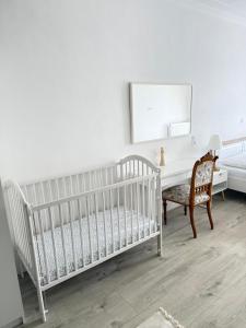 a white crib in a room with a desk and a chair at Penzion Florián Telč in Telč
